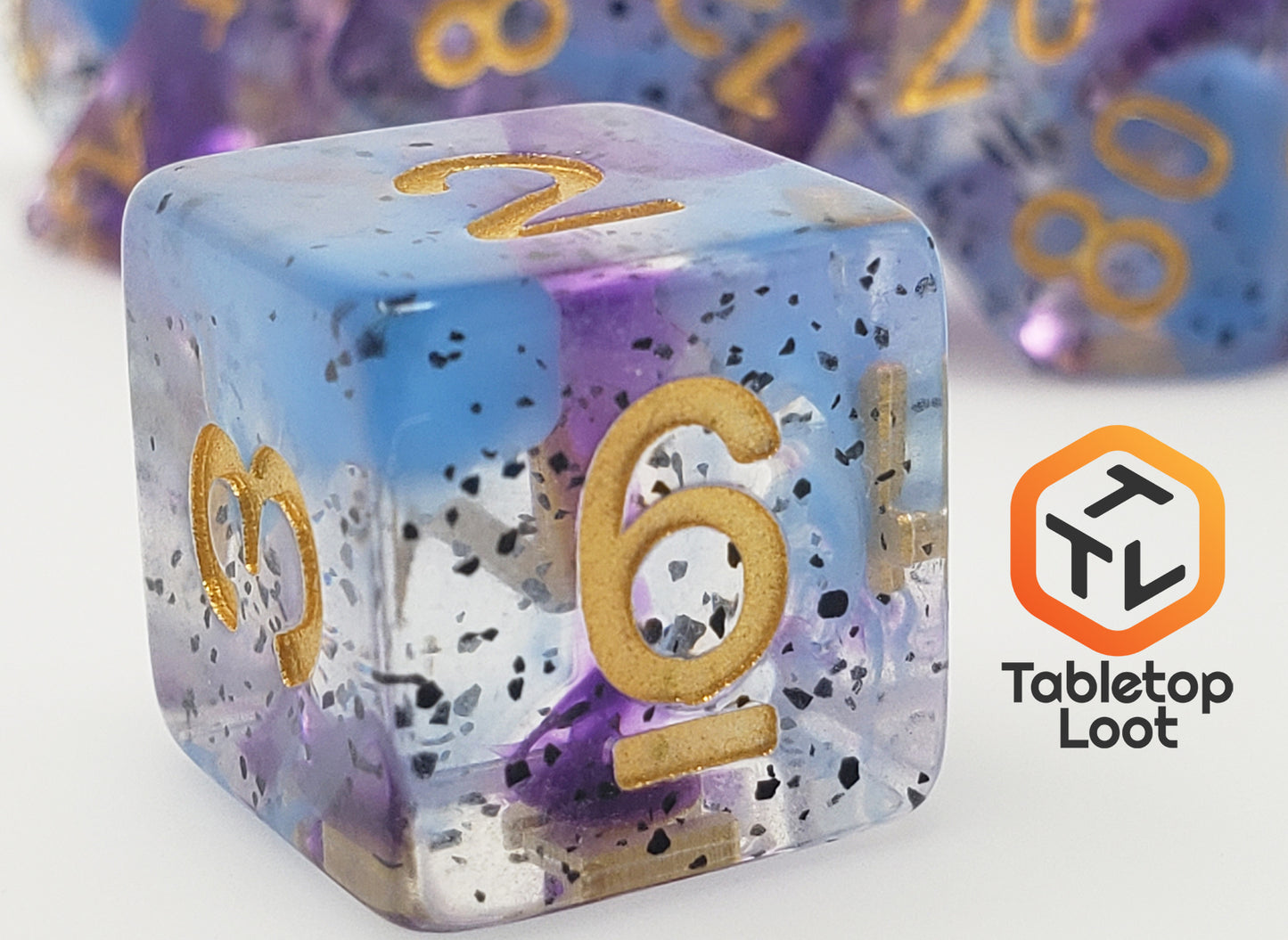 A close up of the D6 for the Infestation 7 piece dice set from Tabletop Loot with swirls of blue and purple and dark speckles suspended in a clear resin with gold numbering.
