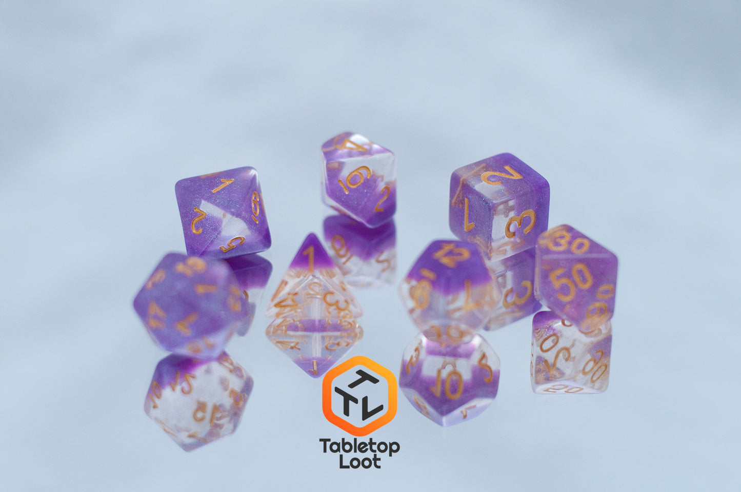 The Gravitational Force 7 piece dice set from Tabletop Loot with a layer of light purple and clear glittery resin.