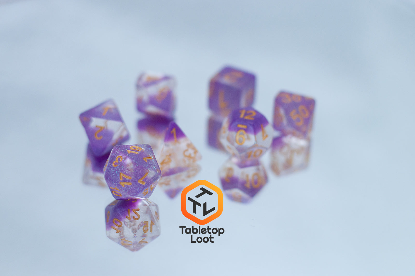 The Gravitational Force 7 piece dice set from Tabletop Loot with a layer of light purple and clear glittery resin.