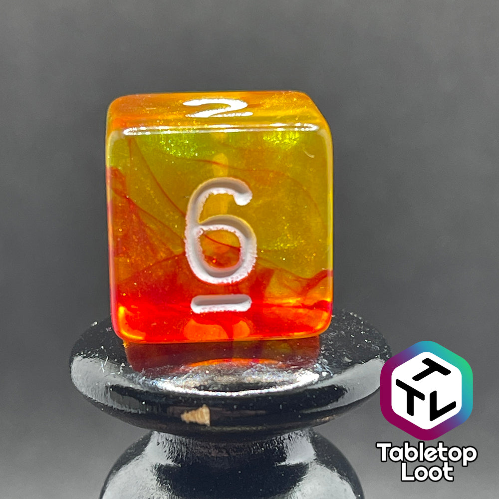 A close up of the D6 from the I Have Walked Though Fire 7 piece dice set from Tabletop Loot with swirls of red in yellow that resemble flames and white numbering.