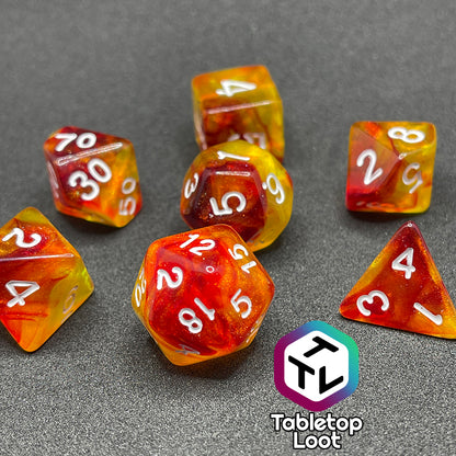 The I Have Walked Though Fire 7 piece dice set from Tabletop Loot with swirls of red in yellow that resemble flames and white numbering.