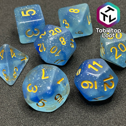 The Water Genasi 7 piece dice set from Tabletop Loot with lots of glitter in two toned blue swirls and gold numbering.