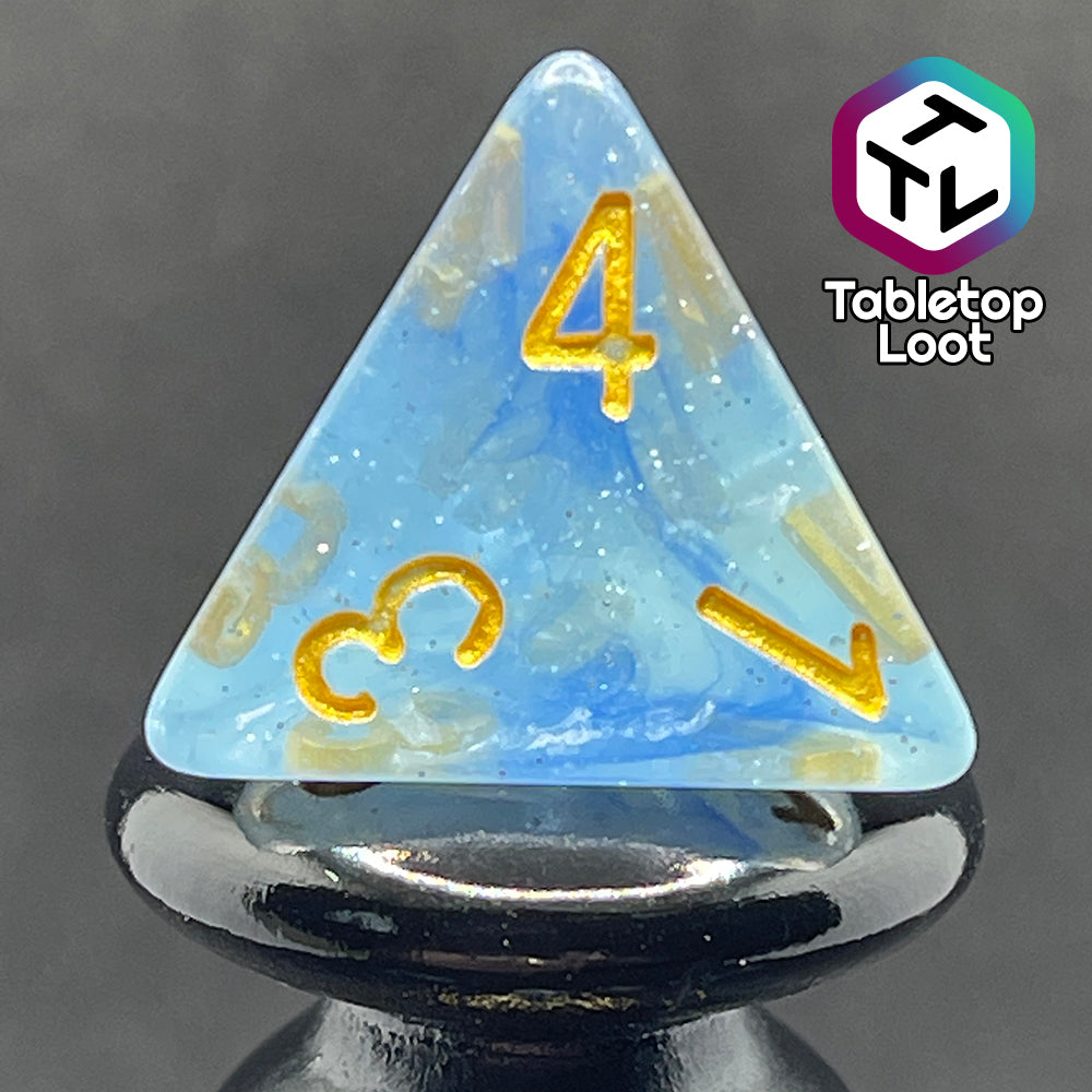 A close up of the D4 from the Water Genasi 7 piece dice set from Tabletop Loot with lots of glitter in two toned blue swirls and gold numbering.