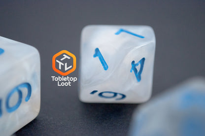 A close up of the D10 from the Dinneshere 7 piece dice set from Tabletop Loot with wispy white swirls and blue numbering.