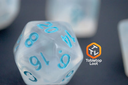 A close up of the D20 from the Dinneshere 7 piece dice set from Tabletop Loot with wispy white swirls and blue numbering.