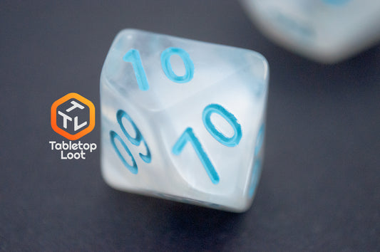 A close up of the percentile die from the Dinneshere 7 piece dice set from Tabletop Loot with wispy white swirls and blue numbering.