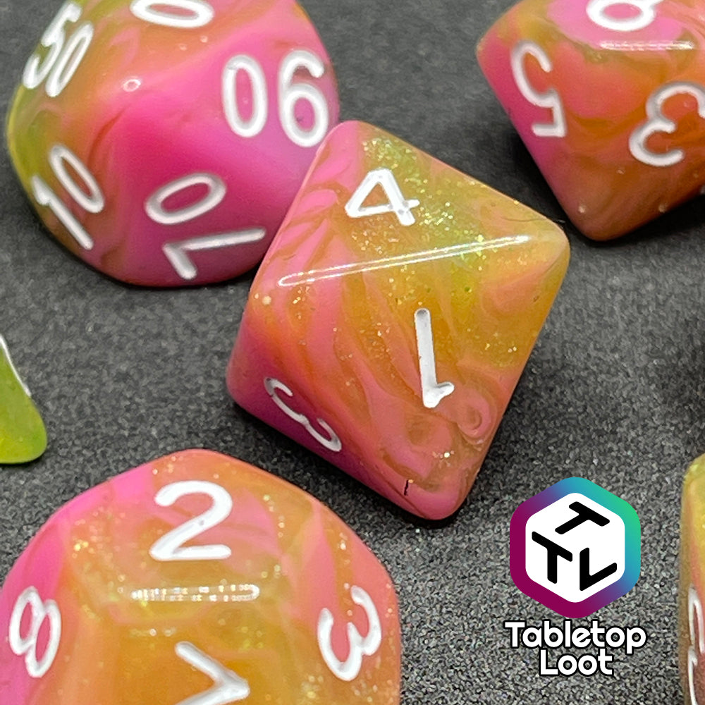 A close up of the D8 from the Wither and Bloom 7 piece dice set with bright pink and glittery green swirls and white numbering.