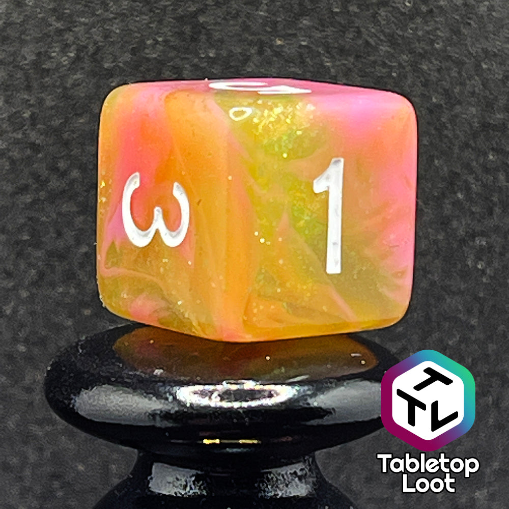 A close up of the D6 from the Wither and Bloom 7 piece dice set with bright pink and glittery green swirls and white numbering.