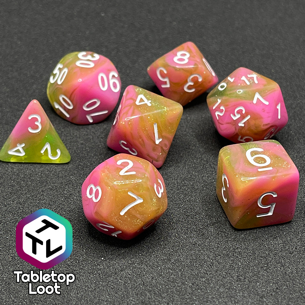 The Wither and Bloom 7 piece dice set with bright pink and glittery green swirls and white numbering.