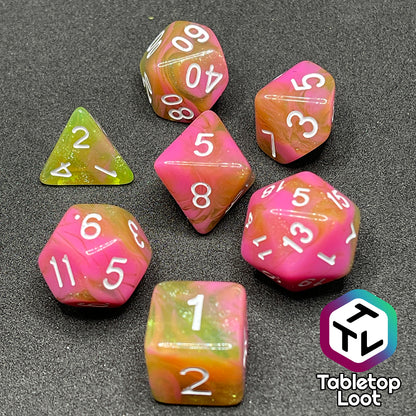 The Wither and Bloom 7 piece dice set with bright pink and glittery green swirls and white numbering.
