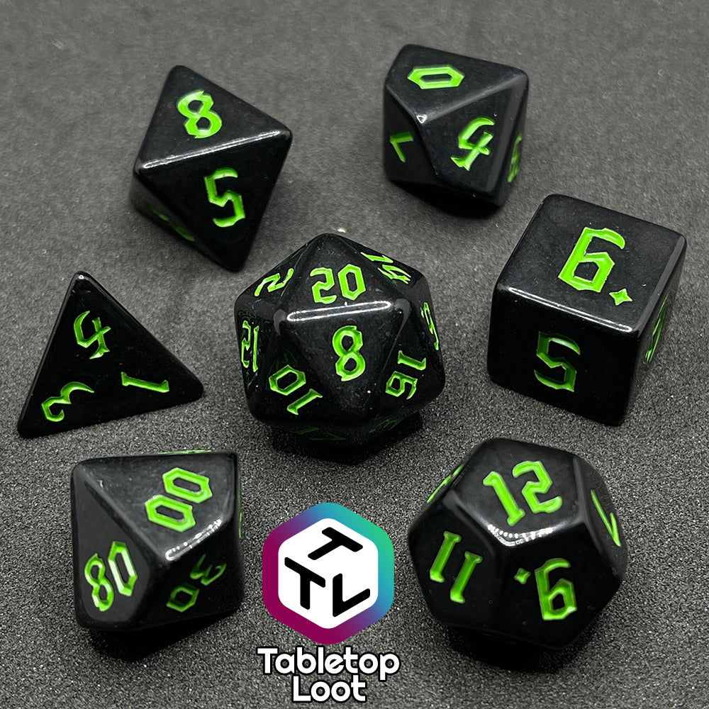 The Xenomorph 7 piece dice set from Tabletop Loot with bright green bold gothic numbers on highly reflective black dice.