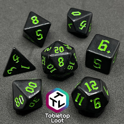 The Xenomorph 7 piece dice set from Tabletop Loot with bright green bold gothic numbers on highly reflective black dice.