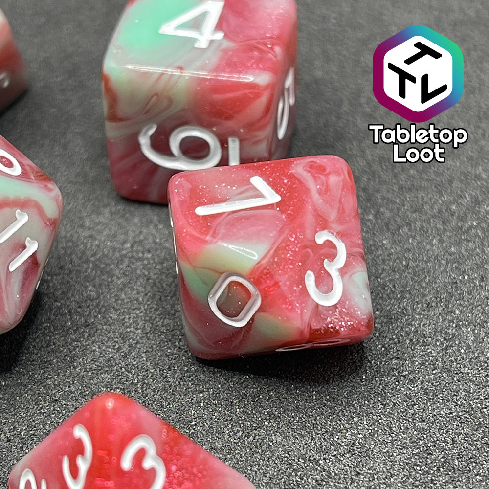 A close up of the D10 from the Zombies 7 piece dice set from Tabletop Loot with sickly green and glittering red swirls and white numbering.