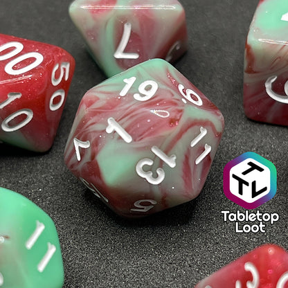 A close up of the D20 from the Zombies 7 piece dice set from Tabletop Loot with sickly green and glittering red swirls and white numbering.