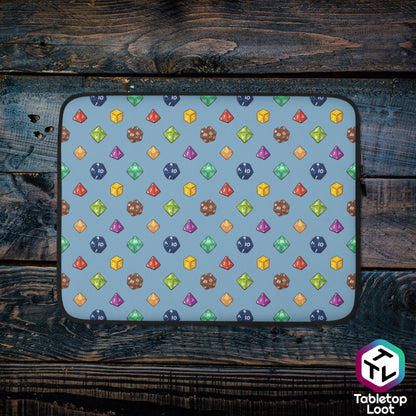 A 13 inch zippered laptop sleeve has a polyhedral dice pattern in red, brown, yellow, teal, blue, and purple on a blue background.